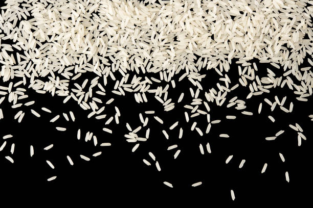 istock Raw white rice splash isolated on blak background top view 938617302