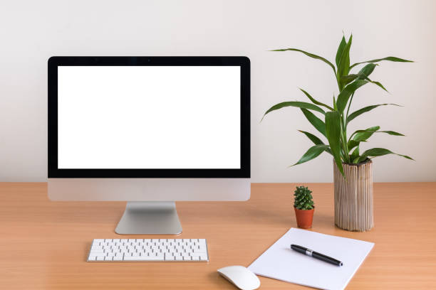 istock All in one computer, mouse, keyboard, paper, pen, cactus and tree vase  on wooden table 938617326