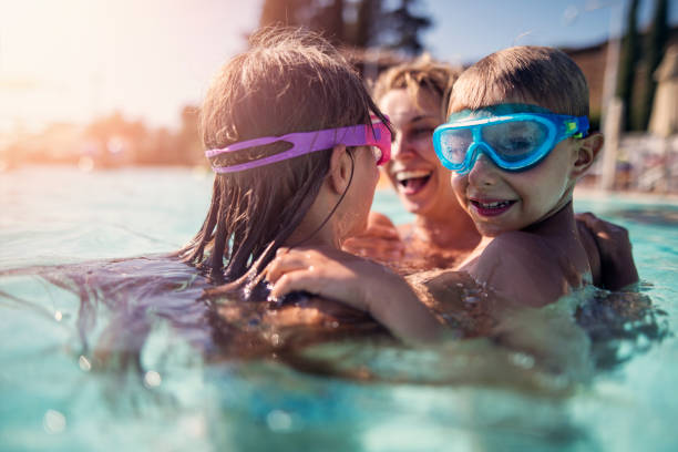 istock Family playing in swimming pool 938617348