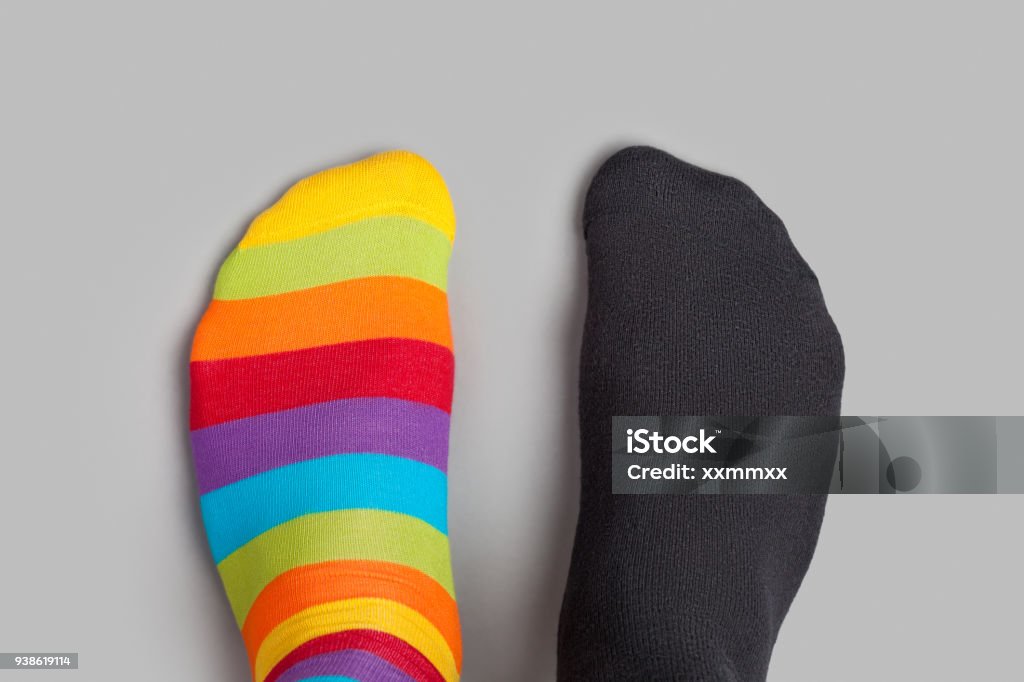 Füße in verschiedenen Farben Socken auf grauem Hintergrund - Lizenzfrei Gegen den Strom Stock-Foto