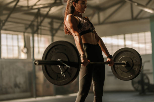 istock Determined and strong woman with heavy weights 938622958
