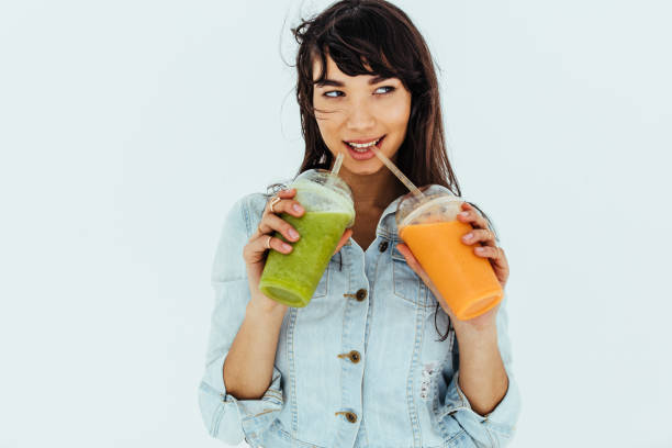 bella donna con due tipi di frullati - smoothie fruit juice healthy eating foto e immagini stock