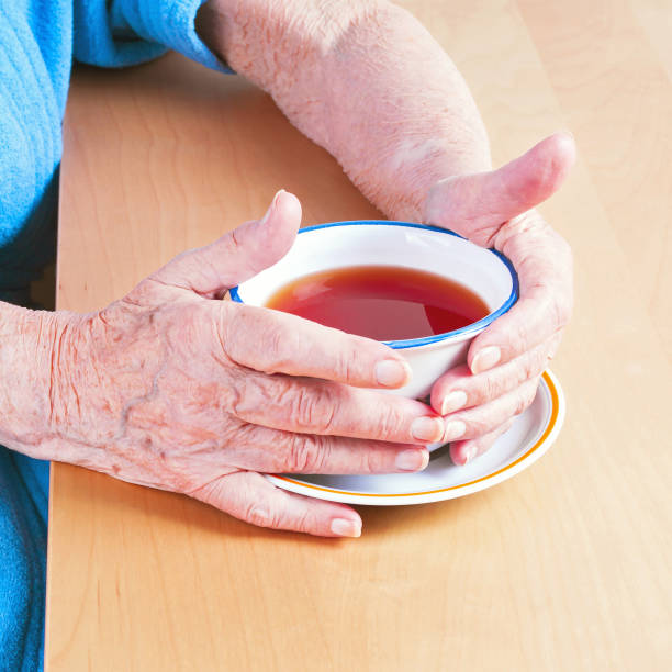 istock Old woman hands holding a cup of tea 938624474