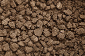 Closeup shot of Soil texture, cultivated dirt, earth, ground, brown land background. Clods of earth in a plowed field in preparation for the next planting. for use organic gardening, agriculture.
