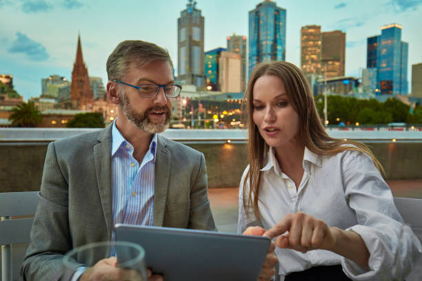 Business colleagues working with digital tablet having a drink after work