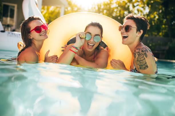 istock Women friends enjoying together in pool 938632090