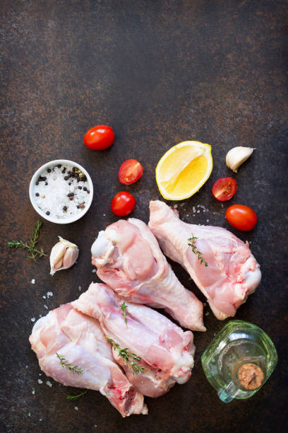 istock Fresh meat. Raw turkey shin, tomatoes, lemons and spices on a stone table. Copy space, top view flat lay background. 938635724