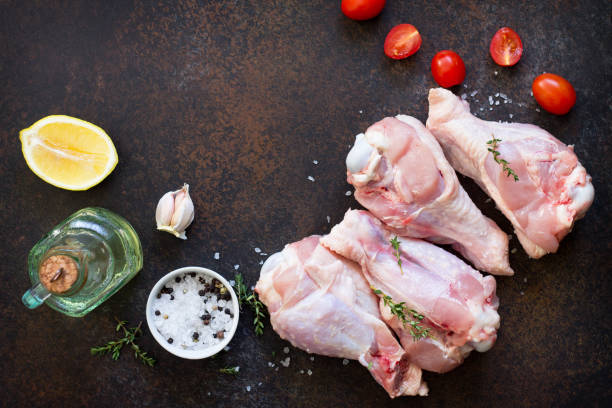 istock Fresh meat. Raw turkey shin, tomatoes, lemons and spices on a stone table. Copy space, top view flat lay background. 938635730