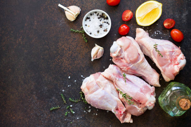 istock Fresh meat. Raw turkey shin, tomatoes, lemons and spices on a stone table. Copy space, top view flat lay background. 938635732