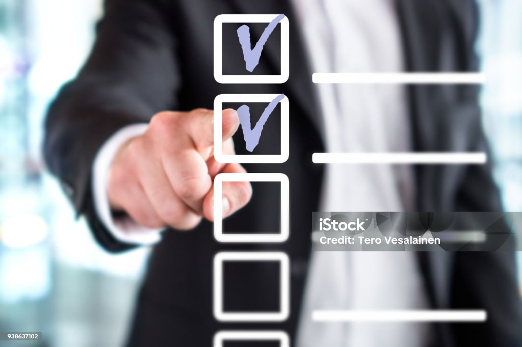 Business man with checklist and to do list. Man writing and drawing v sign check marks with hand and finger in square box. Business man with checklist and to do list. Man writing and drawing v sign check marks with hand and finger in square box. Project management, planning and keeping score of completed tasks concept. Responsibility Stock Photo