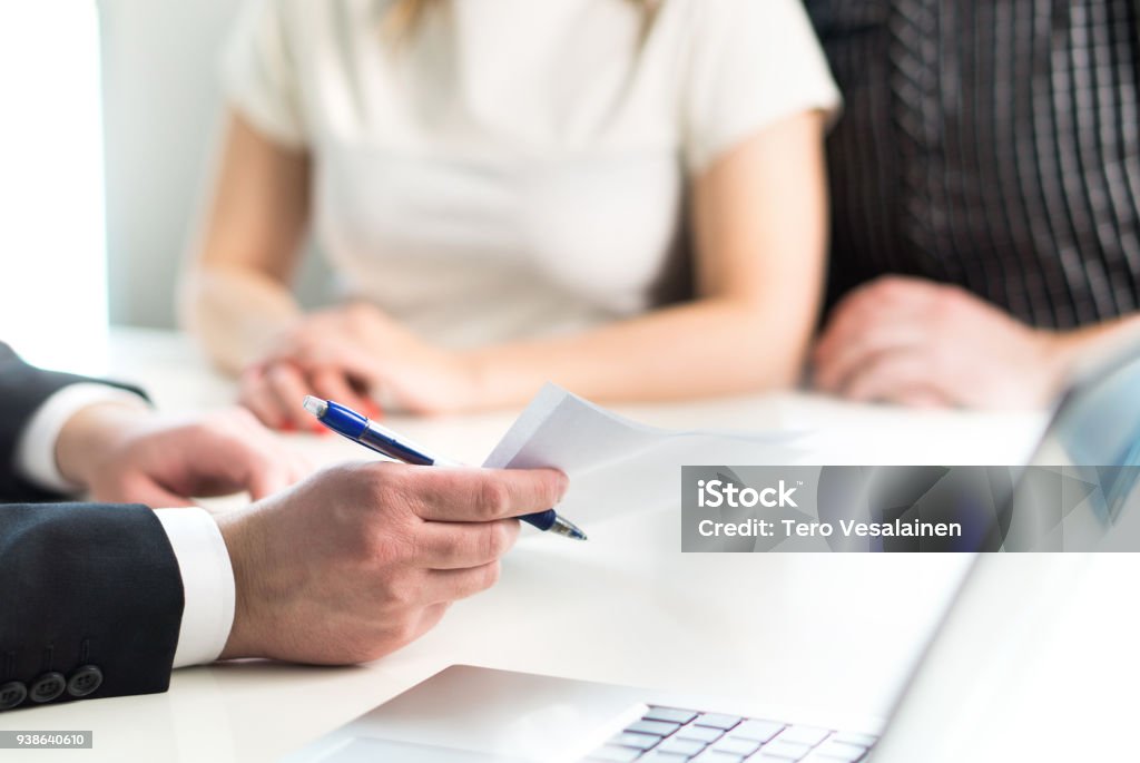 Couple having meeting with legal advisor, real estate agent, businessman or banker. Couple having meeting with legal advisor, real estate agent, businessman or banker. Lawyer giving advice or consultant showing document or agreement to man and woman. Insurance or car leasing paper. Debt Stock Photo
