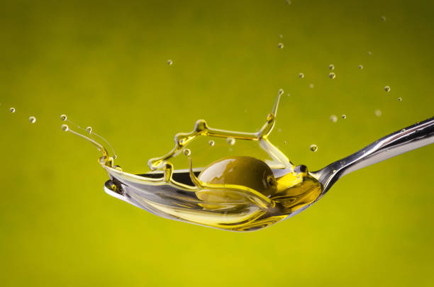 Close up view of olive and extra virgin olive oil with olive leaf on white background with space for text