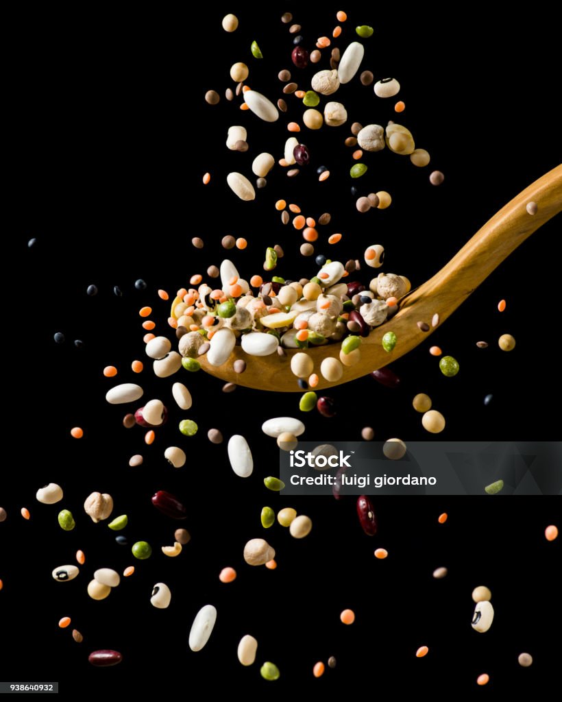 splash of dried vegetable soup dry mixed legumes falling on wooden spoon Legume Family Stock Photo