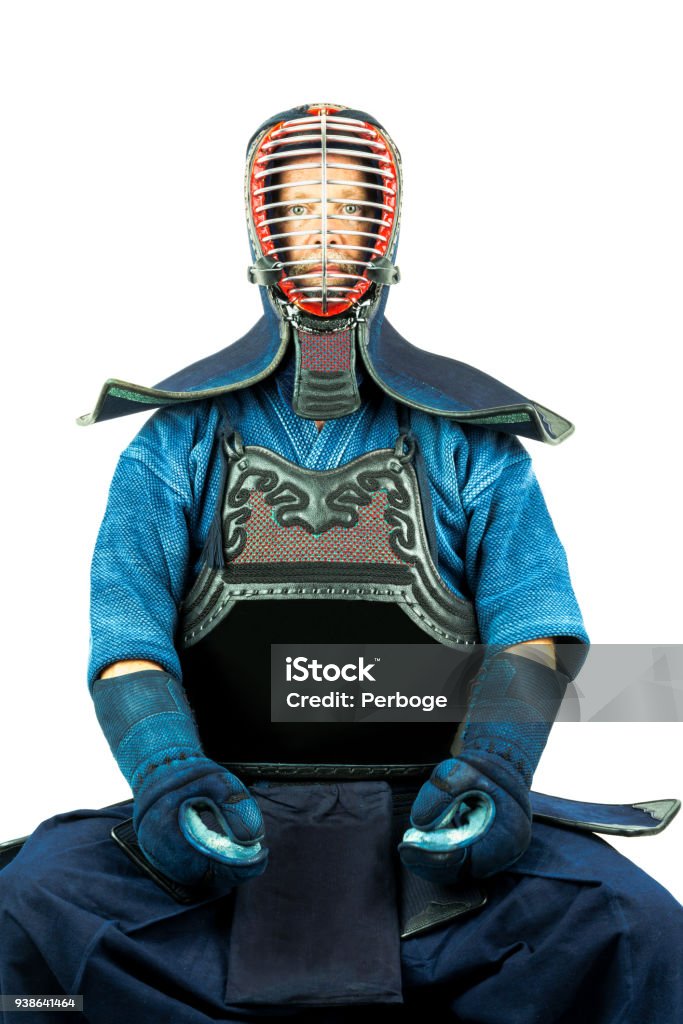 Male wearing a kendo armor with helmet and gloves, sitting position. Male wearing a kendo armor with helmet and gloves, sitting position front view. Adult Stock Photo