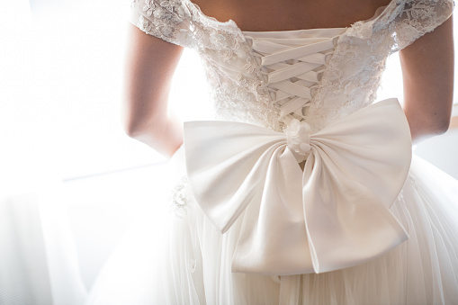 Wedding dress back detail. Close-up of brides beauty against white background