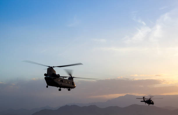 istock Two Military Helicopter flying at sunset 938643882