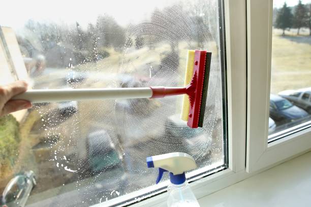 istock Glass squeegee and bottle of window cleaner. 938644562