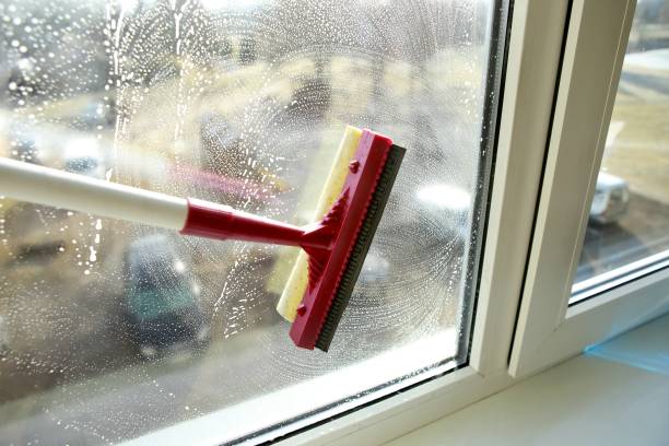 istock Soapy window with a squeegee cleaning the glass. 938644578