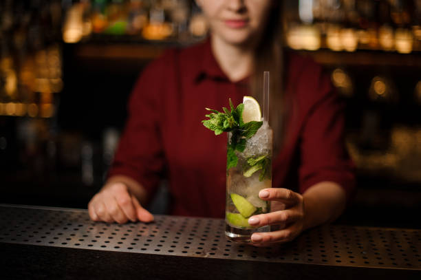 istock Female bartender serving a delicious cocktail Caipirinha 938644610