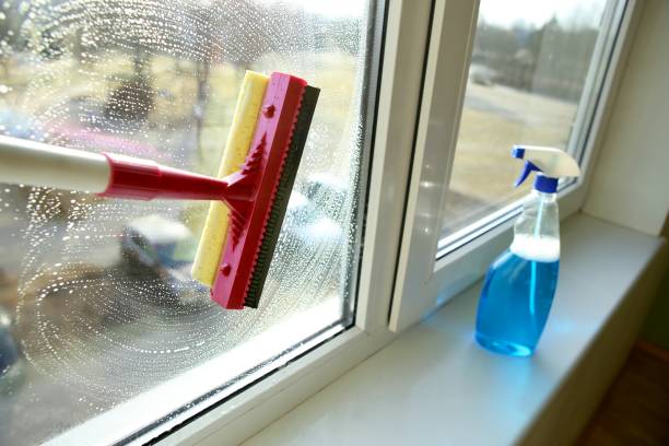 istock Glass squeegee and bottle of window cleaner. 938644640