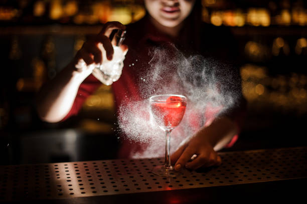 istock Female bartender spraying on the cocktail for serving it 938644682
