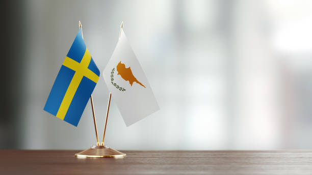 istock Swedish And Cypriot Flag Pair On A Desk Over Defocused Background 938661474