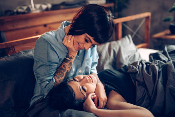 istock Lesbian couple laying on bed and using laptop 938669744