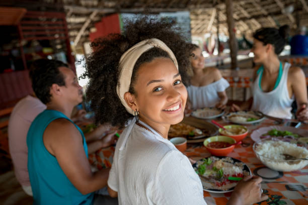brazilian woman eating with friends at a beach restaurant - real food imagens e fotografias de stock