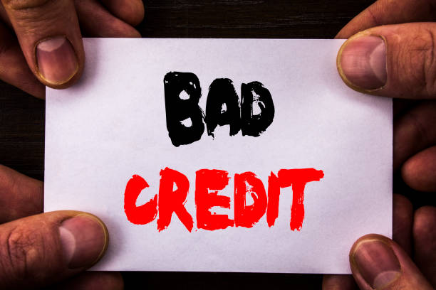 conceptual hand writing text showing bad credit. concept meaning poor bank rating score for loan finance written on sticky note paper holding hand with finger - credit crunch audio imagens e fotografias de stock