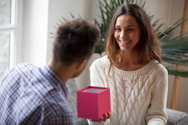 istock Young woman making present giving open gift box to husband 938682752