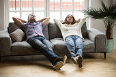 Young couple relaxing together on sofa enjoying nap breathing air