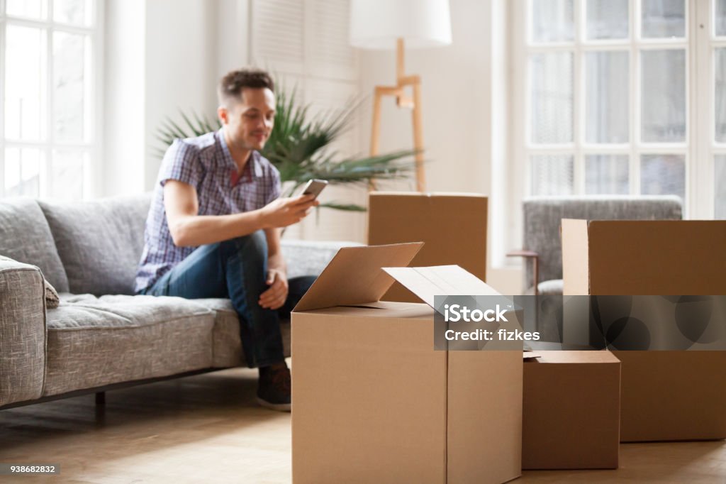 Lleno de cajas de cartón con hombre llamando a servicio a domicilio, móvil concepto - Foto de stock de Reubicación libre de derechos