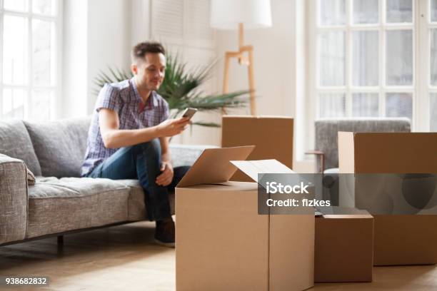 Lleno De Cajas De Cartón Con Hombre Llamando A Servicio A Domicilio Móvil Concepto Foto de stock y más banco de imágenes de Reubicación