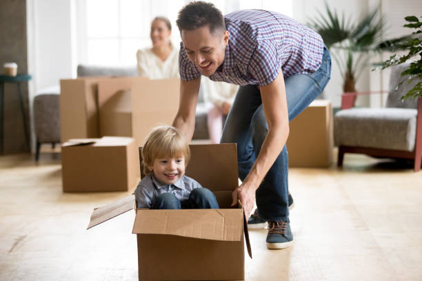 istock Son riding in box playing with father on moving day 938682840