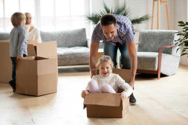 istock Daddy playing with daughter riding in box on moving day 938682852