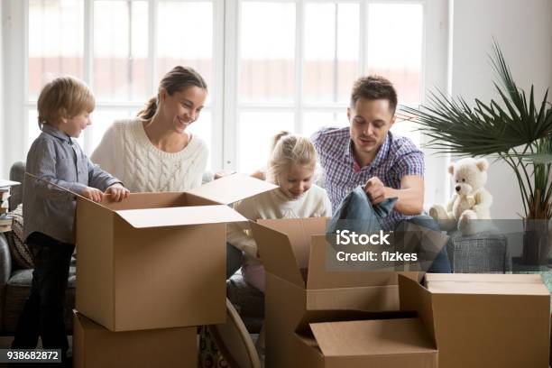 Junge Glückliche Familie Mit Kindern Verpackungskästen Am Umzugstag Stockfoto und mehr Bilder von Familie