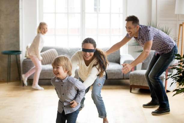 istock Blindfolded mother catching son playing hide and seek with family 938682946