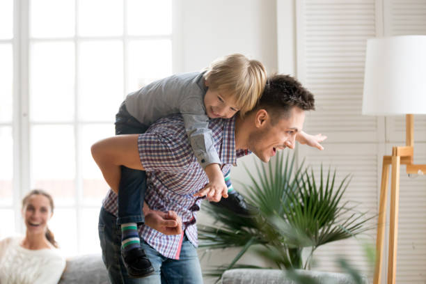 istock Happy dad holding kid son on back giving piggyback ride 938682976