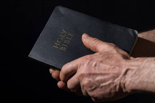 istock Aged man's hands holding the Bible 938683524
