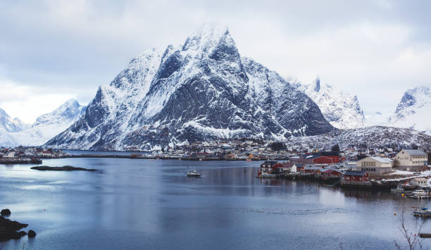 Beautiful super wide-angle winter snowy view of Reine, Norway, Lofoten Islands, with skyline, mountains, famous fishing village with red fishing cabins, Moskenesoya, Nordland Beautiful super wide-angle winter snowy view of Reine, Norway, Lofoten Islands, with skyline, mountains, famous fishing village with red fishing cabins, Moskenesoya, Nordland"n harbor of svolvaer in winter lofoten islands norway stock pictures, royalty-free photos & images