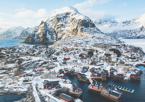 Beautiful super wide-angle winter snowy view of fishing village A, Norway, Lofoten Islands, with skyline, mountains, famous fishing village with red fishing cabins, Moskenesoya, Nordland