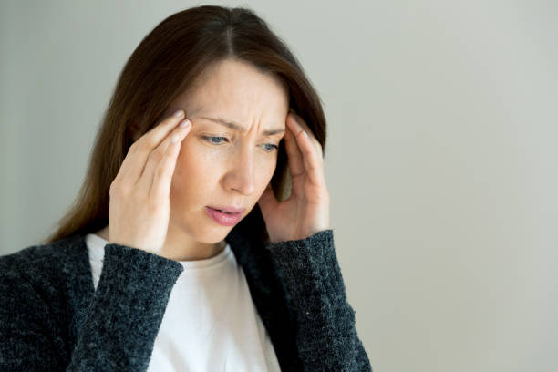istock Woman with hard headache holding hands on head 938691148