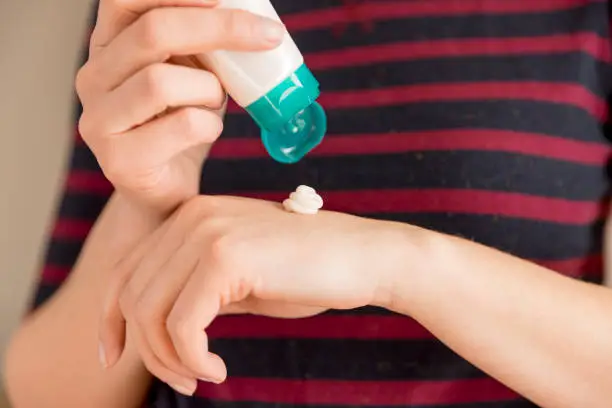 woman's hands applying moisturizing hand-cream on