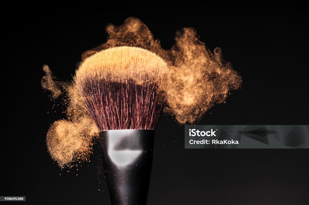 Face powder in motion on a make-up brush on a black studio background Face powder in motion on a make-up brush - Makeup Concept Background Spray Tan Stock Photo