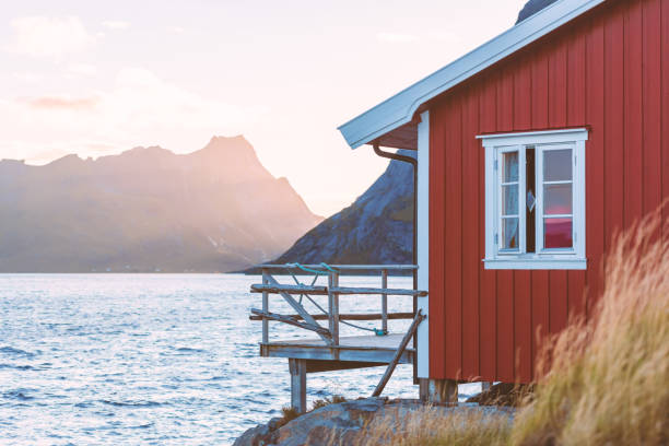 village de la reine sur les îles lofoten en norvège. les maisons traditionnelles en bois rouges et les montagnes. coucher de soleil ciel avec nuages. voyage en scandinavie, l’europe. - house scandinavian norway norwegian culture photos et images de collection