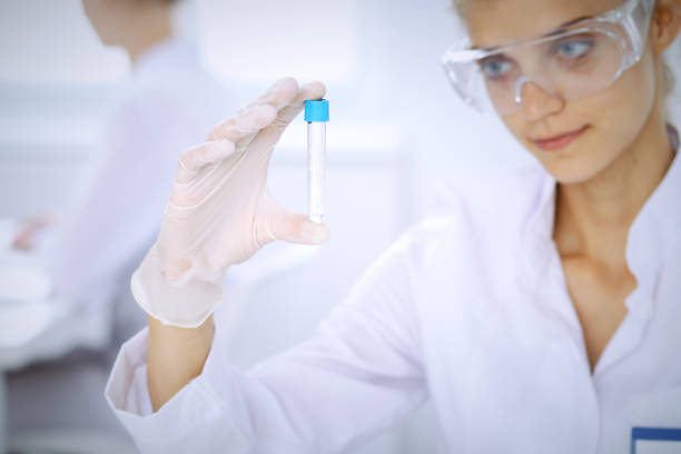 female scientific researcher in laboratory studying substances or blood sample. medicine and science concept - close up medical test exam people imagens e fotografias de stock