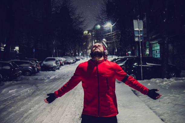 atletyczny człowiek pracujący w mieście w śnieżną noc - harsh lighting audio zdjęcia i obrazy z banku zdjęć