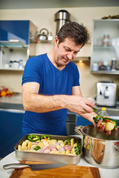 istock Man cooking at home 938717078