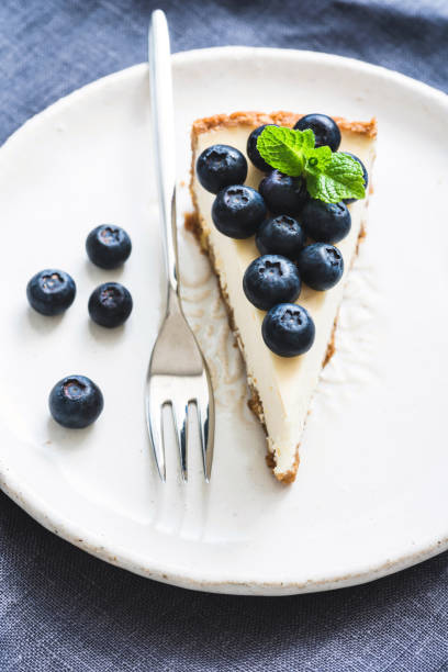istock Cheesecake with fresh blueberries on white plate, selective focus 938720974