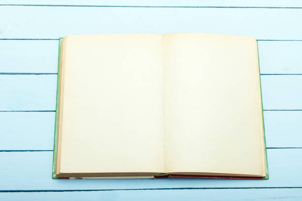 istock Book scetch with empty sheet on blue wooden table. Draft for advertising, announcement. Top view. 938728574